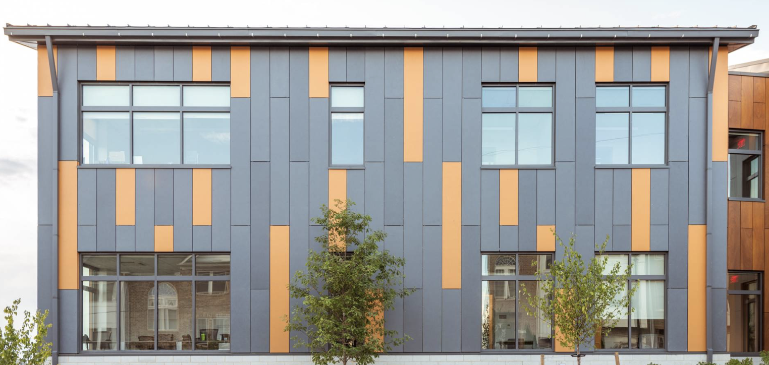 Façade moderne avec panneaux gris et orange.