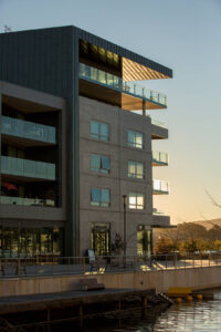 Immeuble moderne au bord de l’eau au coucher du soleil