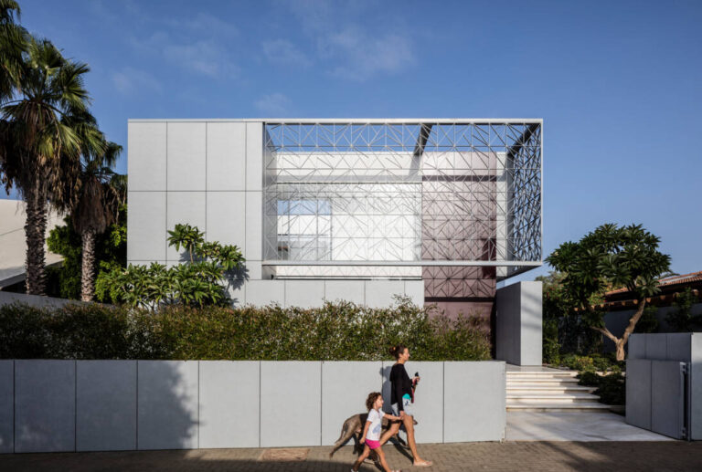 Maison moderne avec façade géométrique et promeneurs.