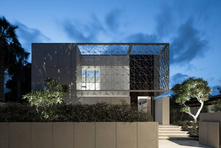 Maison moderne avec façade géométrique illuminée au crépuscule